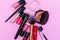 Banner. Make up the essentials. A set of professional makeup brushes and cosmetics on a pink background