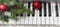 banner with New Year or Christmas music concept. piano with a branch of a Christmas tree, pine cones and red Christmas