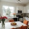 banner ofa kitchen with tulips on the table and white cupboards food on the kitchen counter top