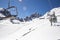 Banner panorama of ski resort, skiers on the ski lift, white snow pine trees at pink sunset or dawn