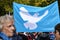 Banner of the peace movement with a white dove on a blue background at a demonstration for autumn solidarity