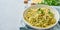 Banner with pesto pasta, bavette with walnuts, parsley, garlic, nuts, olive oil. Side view, long side, copy space, blue background