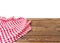 Banner of Red Checkered tablecloth top view  on white background. Brown wooden table. Selective focus. Copy space. Place