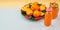 Banner Red plate with oranges and tangerines green leaves bottle with juice on light background Top view copy space