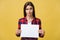 Banner sign woman peeking over edge of blank empty paper with copy space for text. Beautiful Caucasian woman looking