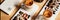 Banner size image of two cups of Hot latte with baked caramel crust and sweet roll with banana and strawberry on the wooden table