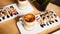Banner size of two cups of Hot latte with baked caramel crust and sweet roll with banana and strawberry on the wooden table in