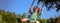 Banner with spring child face. Child swing on backyard. Kid playing oudoor. Happy cute little boy swinging and having