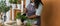 Banner Spring hobby happy african american woman transplanting in flower pot houseplant with dirt or soil at home