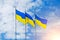Banner with three Ukrainian flags on a background of blue sky and rising sun