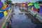 BANYUWANGI, INDONESIA: Water channel seen from bridge with colorful houses on both sides, charming neighborhood, cloudy