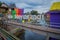 BANYUWANGI, INDONESIA: Water channel seen from bridge with colorful houses on both sides, charming neighborhood, cloudy