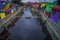 BANYUWANGI, INDONESIA: Water channel seen from bridge with colorful houses on both sides, charming neighborhood, cloudy