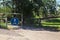 Bar with a blue sign at the beginning of a path bordered by trees in the italian countryside