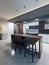 Bar counter with chairs and a kitchen island in a modern kitchen, evening lighting