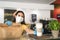 Bar owner working only with take away orders during corona virus outbreak - Young woman worker wearing face surgical mask