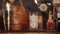 Bar rack with tall glass with ice cubes inside, barman is moving in background