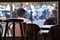 Bar stools and chairs with patrons and street in background