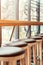 Bar stools stand in a row along the window in a cafe