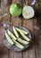 Barattieri are kind of Italian cucumber, sliced on the plate, wooden table, wild flowers