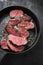 Barbecue dry aged wagyu sirloin beef steak sliced with salt and pepper on a gray cast iron design pan