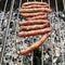 Barbecue with fiery Bavarian sausages on grill in garden outdoors