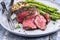 Barbecue wagyu point steak with green asparagus and mushroom cap on a modern desing plate