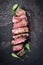 Barbecue wagyu sirloin steak slices with lettuce and herbs on a board