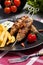 Barbecued kofta - kebeb with fries and vegetables on a plate