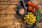 Barbecued organic olives with herbs in plate. Wooden background. Top view. Copy space