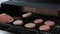 Barbecuing plant based Impossible Burger patties on electric grill semi close up shot panning over spatula flipped and