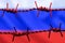 Barbed wire on background of flag of Russia. Sanctions against Russia