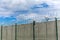 Barbed wire and concrete wall. Military base. State border. Prison wall. Security concept. Safety device