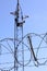 Barbed wire fence and surveillance cameras provide security - blue sky background with copy space