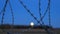 Barbed wire over abstract full moon sky background. Border with barbed wire of prison during night time with moon