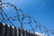 Barbed wire over a high fence protects against illegal entry