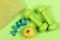 Barbells, apple and tape measure near green towel