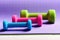 Barbells in different colors placed in pattern, close up