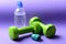 Barbells next to cyan ruler and water bottle, close up