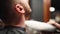 Barber applies talc powder with brush on client`s neck after shaving beard and haircut in hair salon. Hairdresser cleans