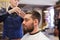 Barber applying styling spray to male hair