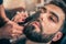Barber beard cut a client\'s beard with clippers