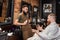 Barber and bearded man in barber shop