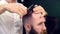 Barber behind client cutting hair on forelock with fingers, scissors. Cropped side view of bearded man getting haircut