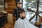 Barber with comb and hairdryer makes a hairstyle