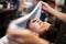 Barber covers the face of a man with a hot towel. Traditional ritual of shaving the beard with hot and cold compresses in a old