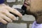 The barber cuts his beard to a guy with a shearing machine