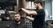 Barber cutting hair with brush and hair trimmer