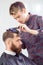 Barber cutting hair with scissors.