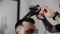 Barber dries hair and makes hair styling for customer at barber shop, man`s haircut and shaving at the hairdresser